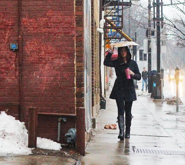 Madison residents find creative ways to deal with the rainy weather, using cardboard boxes as makeshift umbrellas.