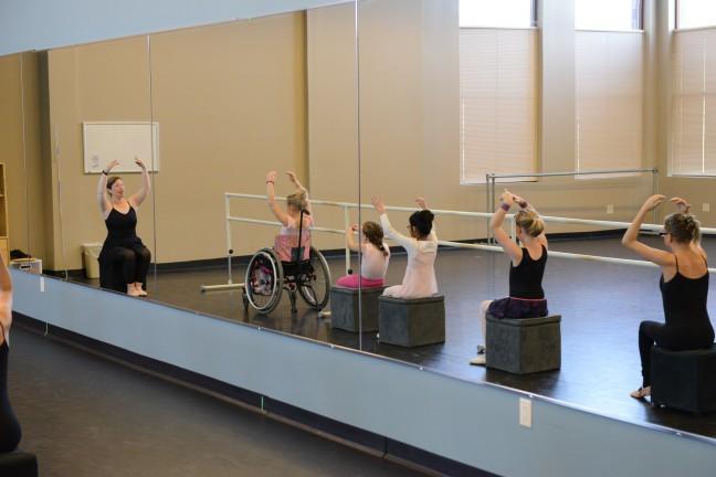 Dance instructor brings seated dance students