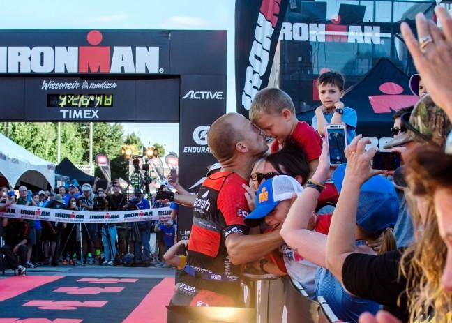 Ironman+champion+Edward+Schmitt+of+Lake+Mills+stops+for+a+special+moment+before+his+finish.+