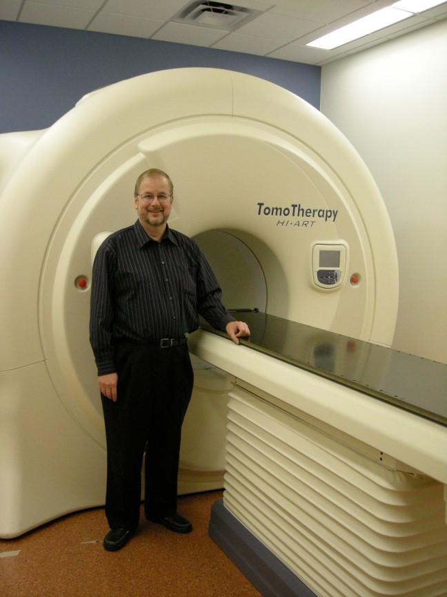 Mackie with one of three TomoTherapy machines at UW