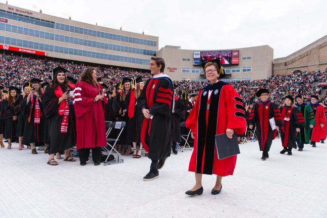 David Muir and Chancellor Rebecca Blank walk to give their commencement addresses