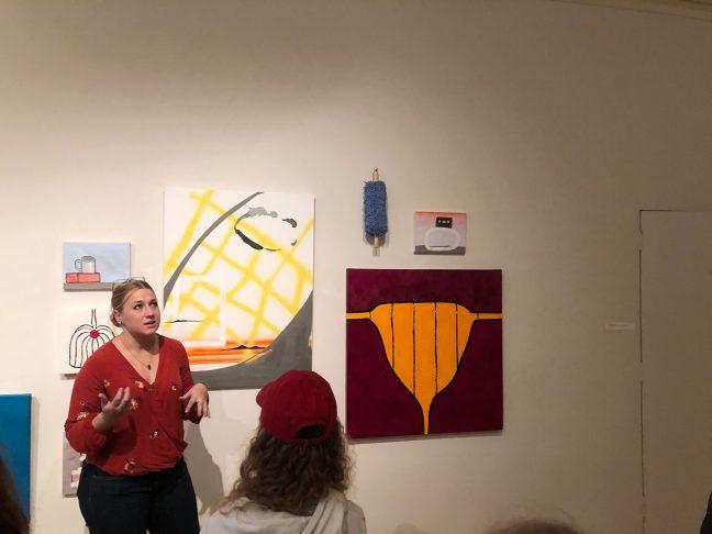Jaymee Willms explaining Melissa Dorns displayed piece Women.