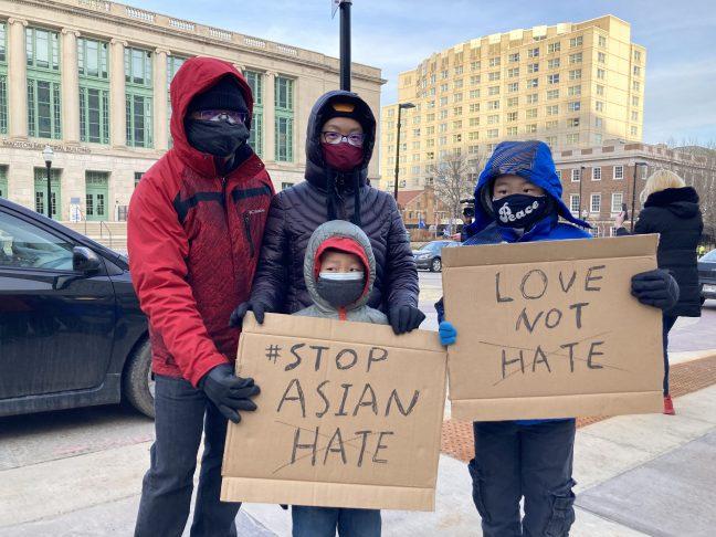 A family of four from the Madison Asian Americans community hold two signs that read ‘Stop Asian Hate’ and ‘Love Not Hate’, as hundreds gathered for the ‘March for Asian American Lives’ rally against the shootings that occurred in Atlanta, during the rise in racist hate crimes towards Asian American community across the United States, in front of the Madison City Hall, on March 18, 2021