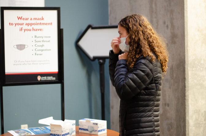 A student puts on a mask at University Health Services. February 7, 2024. 