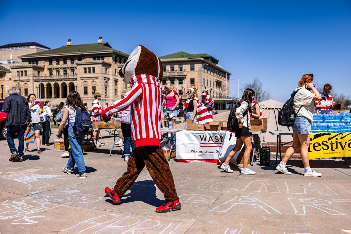 Bucky greets students grabbing free breakfast at Library Mall as part of WASB's 
