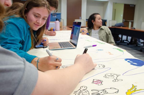 Members of the ASM Sustainability committee work on a poster during a meeting in the SAC on April 11, 2024. They are heading an Earth Day "Plastics vs. People" campaign in collaboration with earth.org.