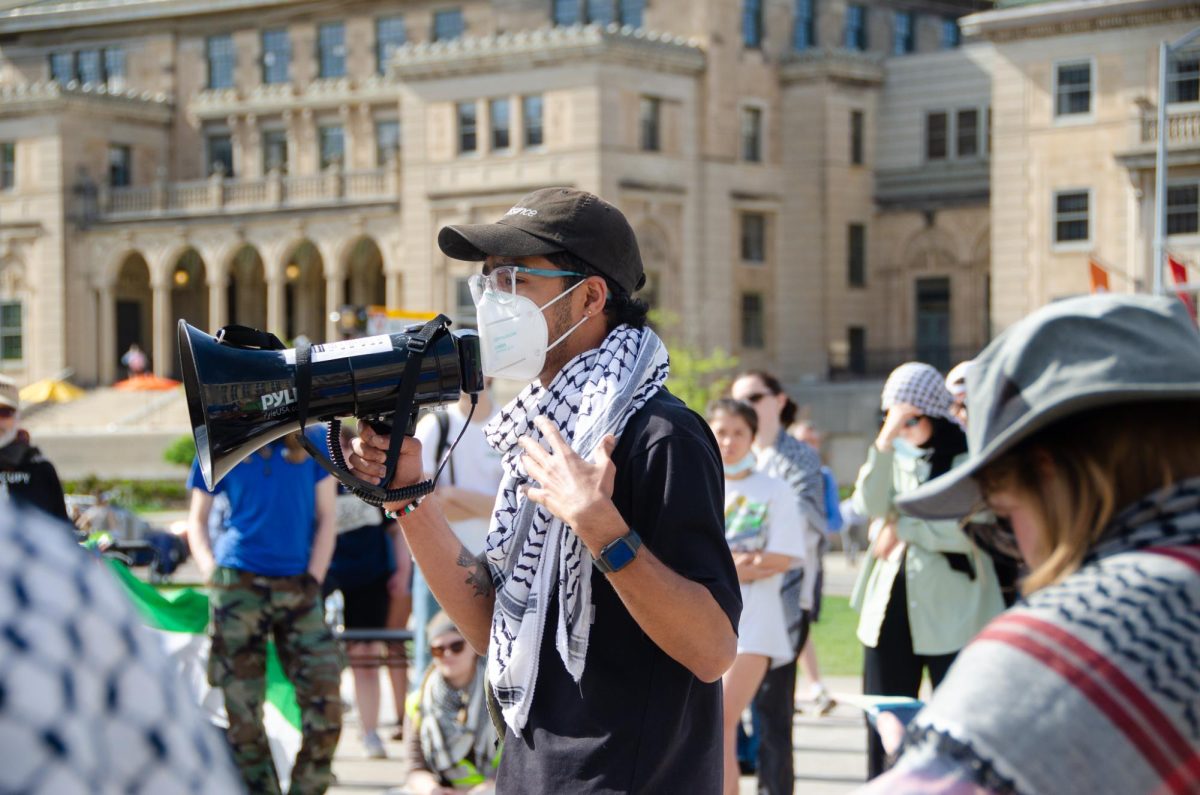 A lead organizer announces updates about negotiations with the University of Wisconsin-Madison at Library Mall on May 8, 2024.