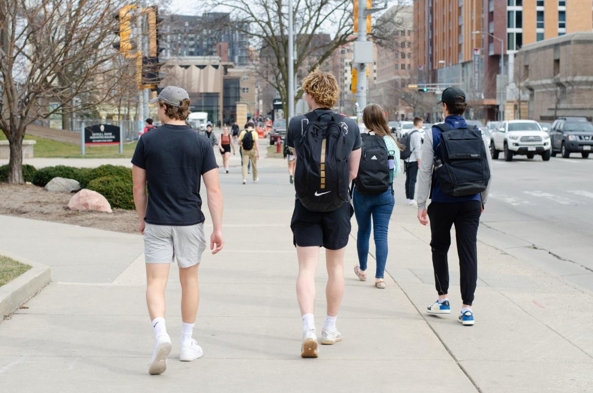 Killian Weston (left) and Jack Couey walk down University Ave. as they head to the Kohl Center to film their first TikTok of the day. The two typically film on Tuesdays, but do not come in with a game plan, instead making video ideas up on the spot. Today the concept they are building around is a promotion for the app BeReal.  