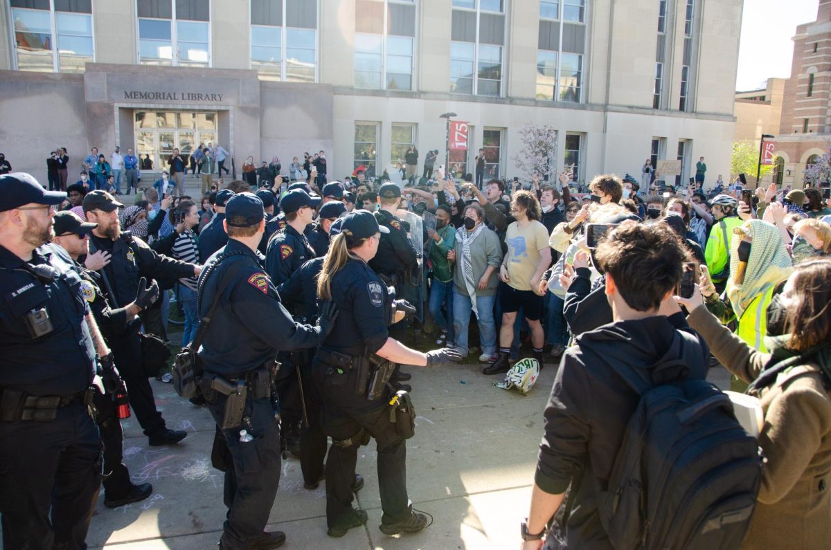 Law enforcement officers back away as demonstrators push them out of the Library Mall encampment. May 1, 2024. 