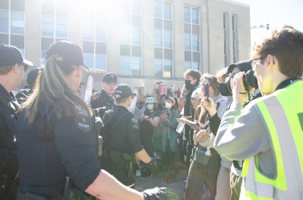 Police officers step back from the large group of protesters at Library Mall on May 1, 2024. 