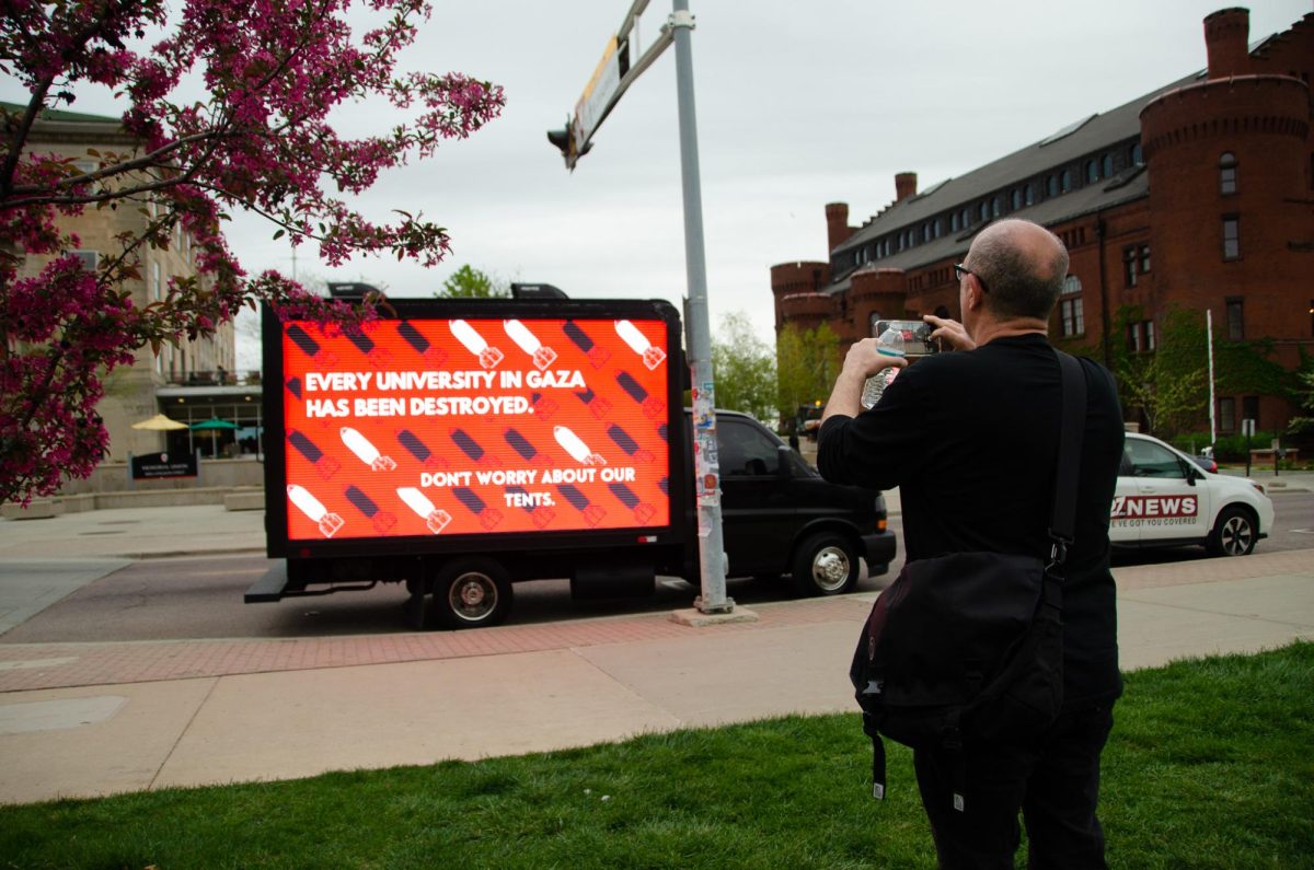 Demonstrators take photos of a truck displaying messages to UW-Madison in support of Gaza. The advertisement truth was paid for by an anonymous source, with another being sent to the University of Wisconsin-Milwaukee. 