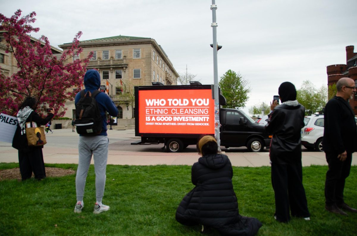 Demonstrators take photos of a truck displaying messages to UW-Madison in support of Gaza. The advertisement truth was paid for by an anonymous source, with another being sent to the University of Wisconsin-Milwaukee. 