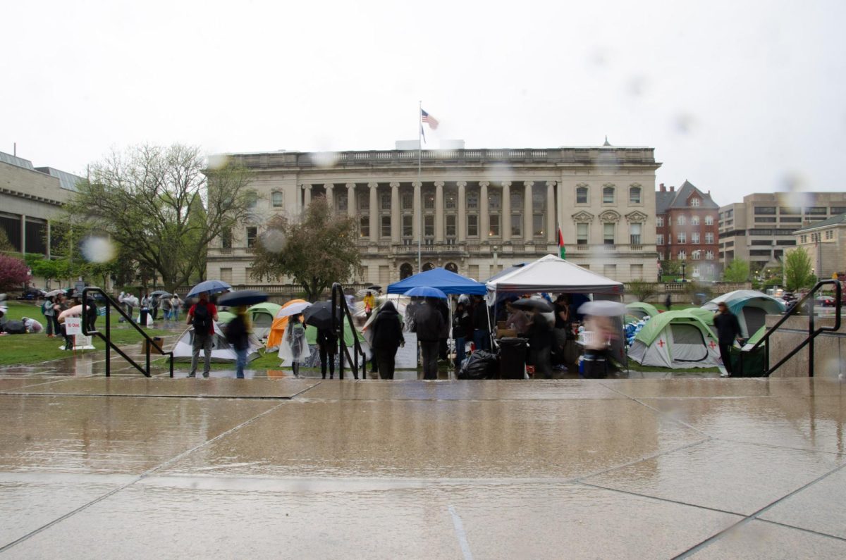 Demonstrators take cover from the rain at the Library Mall encampment on May 2, 2024.
