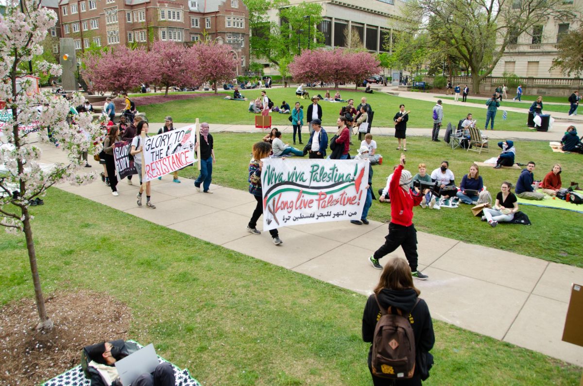 Demonstrators march around Library Mall, chanting and displaying banners, on May 2, 2024. 