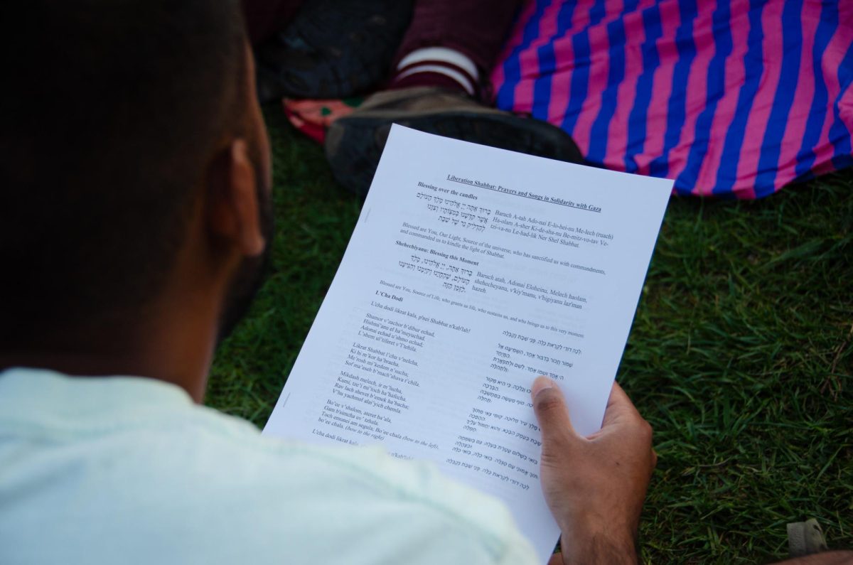 A demonstrator holds a prayers and songs pamphlet at a Liberation Shabbat at Library Mall on May 3, 2024. 