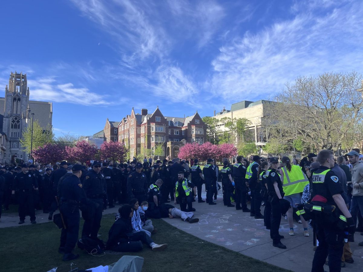 Police stand around the encampment on Library Mall. Protesters who have been arrested are sitting on the ground. May 1, 2024.