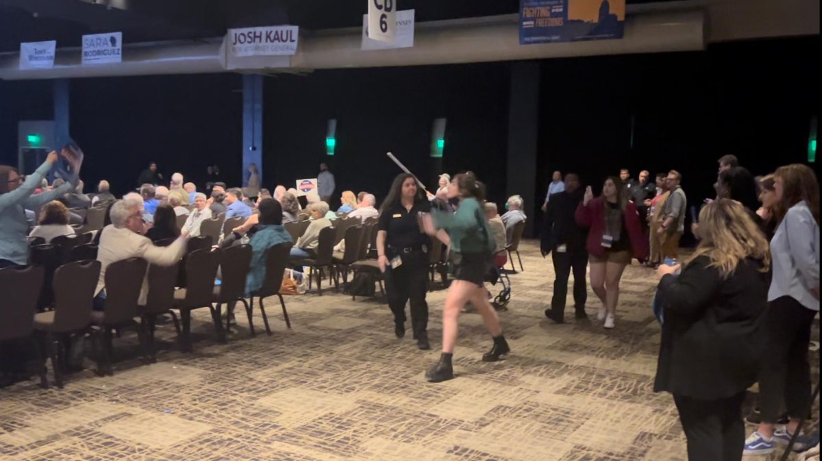 Event organizers escort two pro-Palestinian protesters out of the convention center during Sen. Tammy Baldwins speech. June 8, 2024. 
