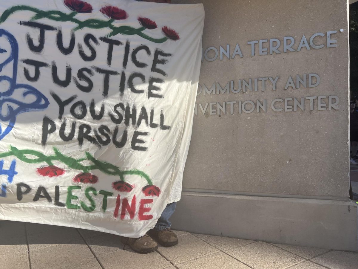 Pro-Palestinian protesters hold a sign outside Monona Terrace. June 26, 2024.