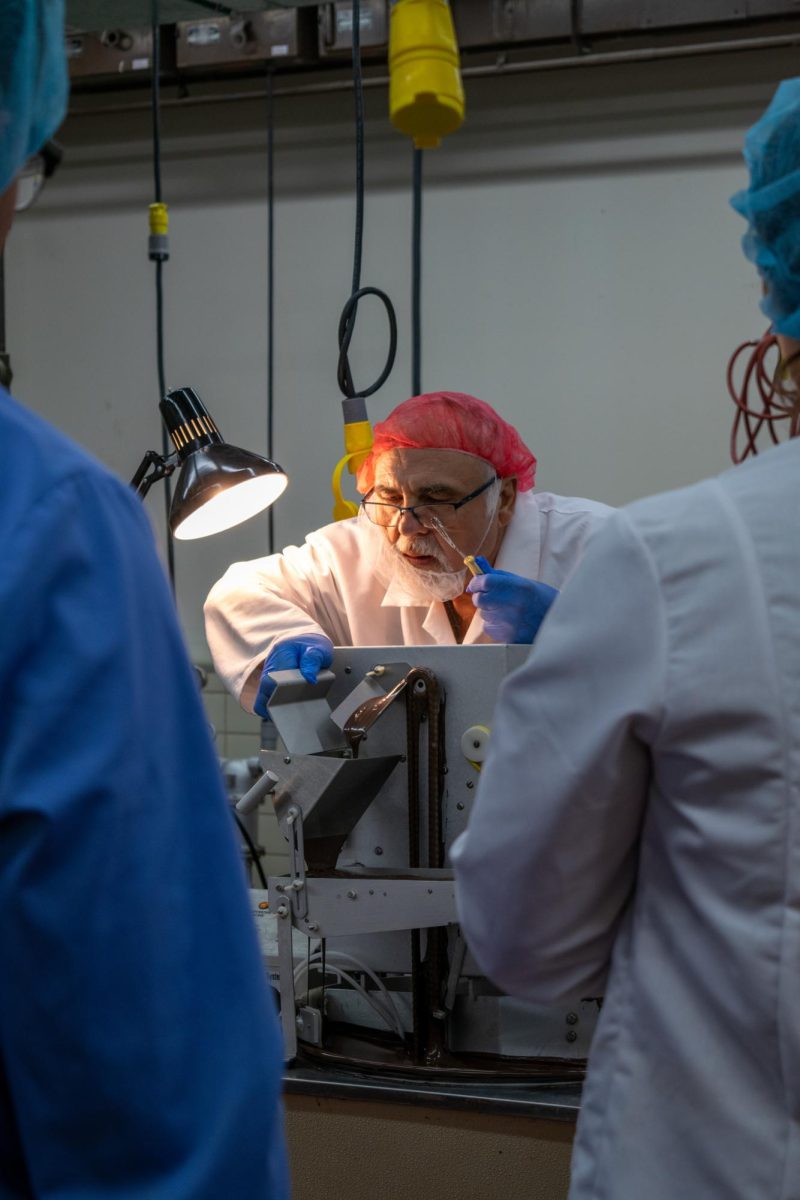 Instructor showcases piece of equipment to students as part of chocolate laboratory. Aug. 2, 2024. 