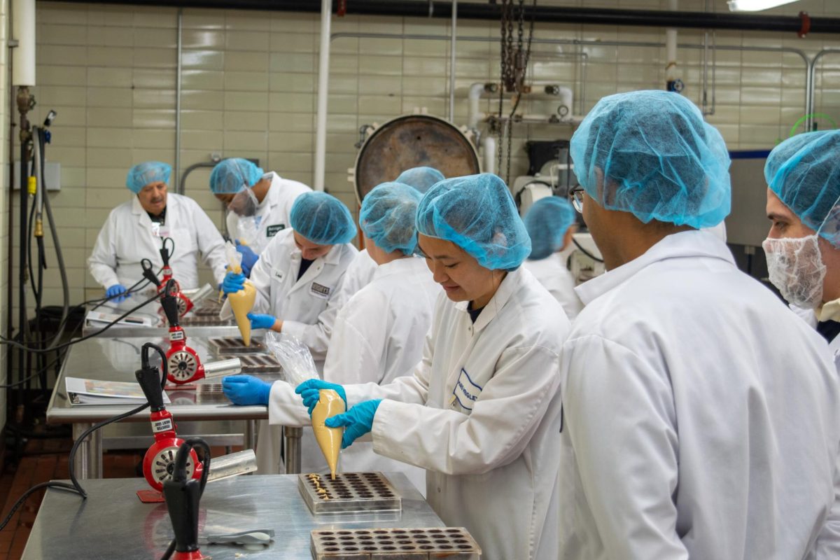 Students fill chocolate mold as part of 
chocolate laboratory experiment. Aug. 2, 2024. 