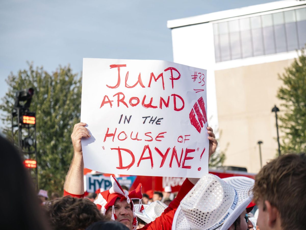 Fan holds sign at the Fox Big Noon Kickoff event on the Kohl Center lawn. 