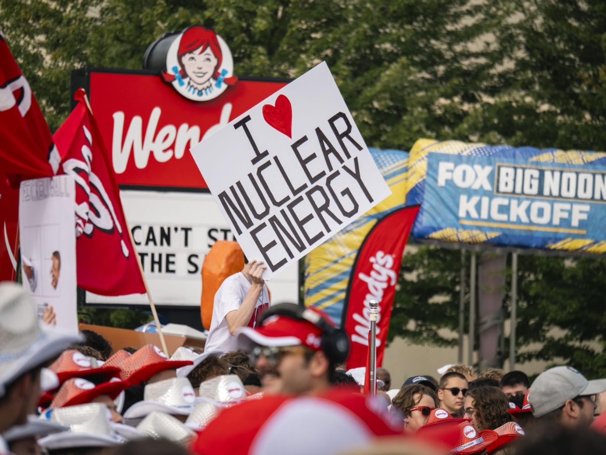 Student holds sign at the Fox Big Noon Kickoff event on the Kohl Center lawn. 