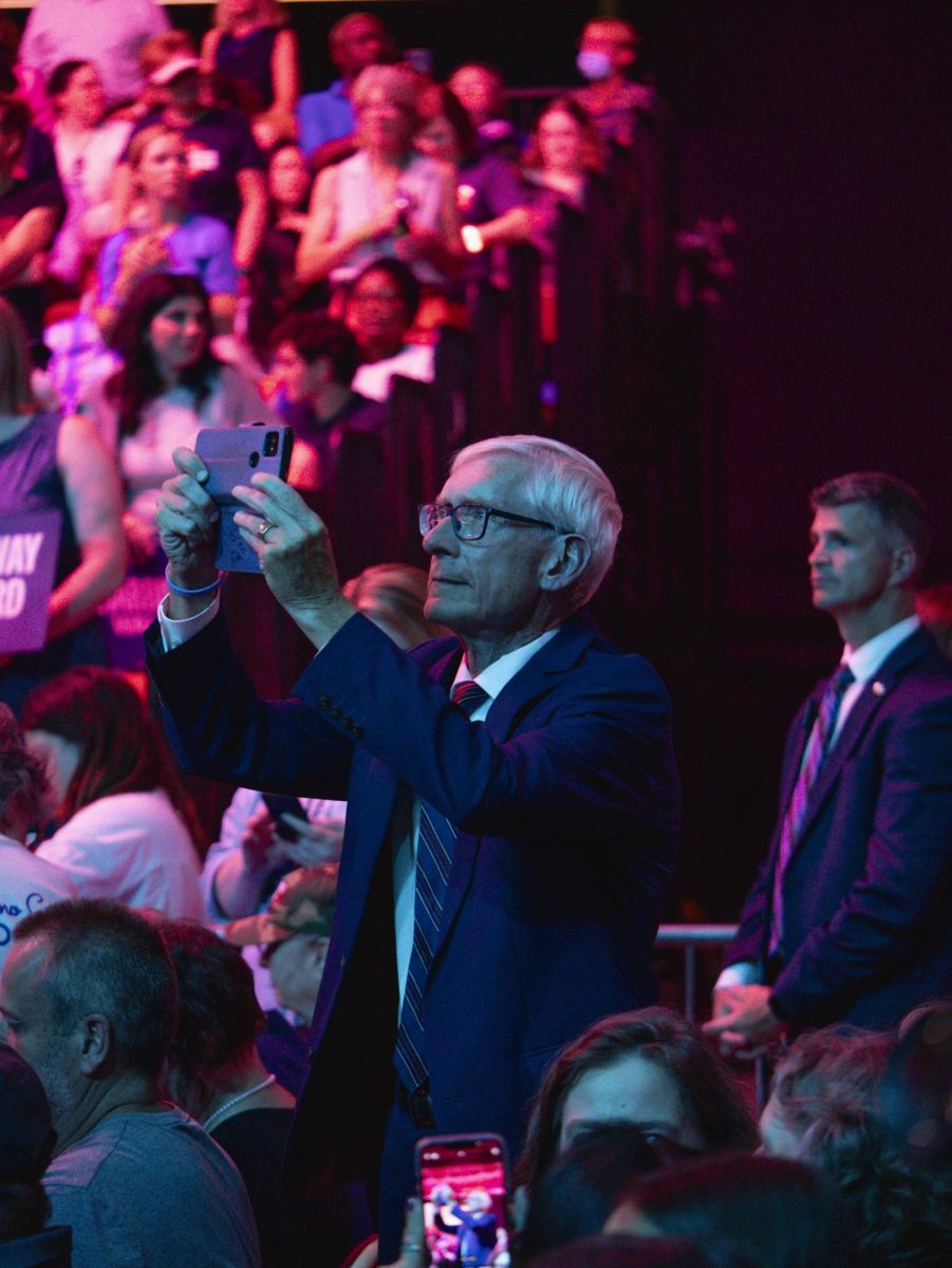 Gov. Tony Evers takes a photo of Kamala Harris at her rally in Madison. 