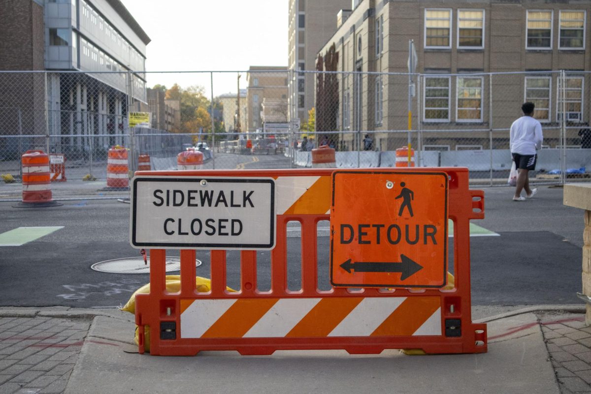 Student walks in the street due to Engineering Hall construction. 