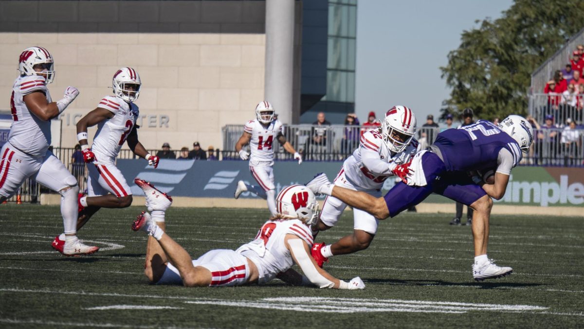 Badgers players attempt to tackle Northwestern player. 