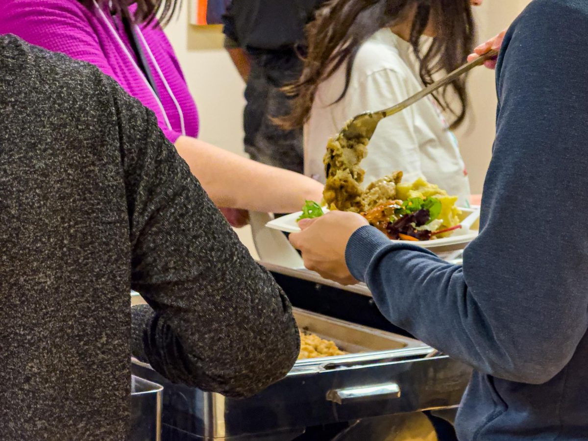 Student dishes food at the Wisconsin Union's Friendsgiving. November 19, 2024.