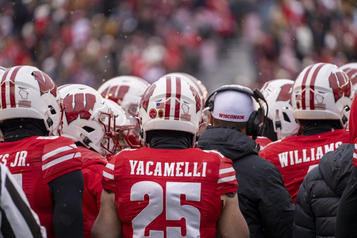 Badgers players huddle while it starts to snow. November 29, 2024. 