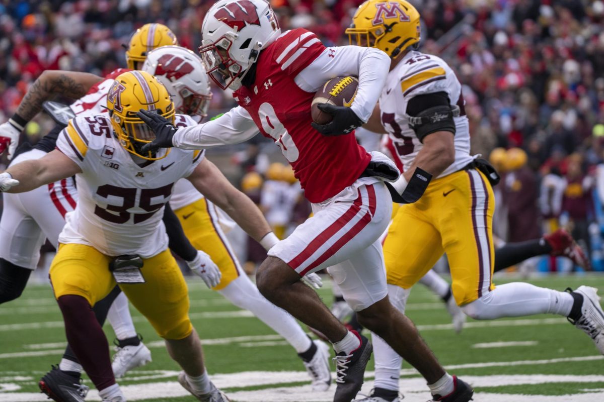 The Badgers' Anthony II runs and stiff-arms a Minnesota defender. November 29, 2024. 