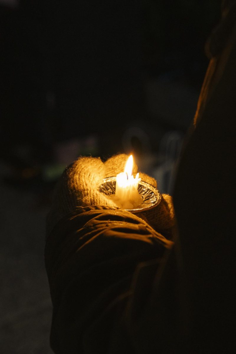 Crowd member holds a candle for the Abundant Life Christian school shooting vigil. December 17, 2024.