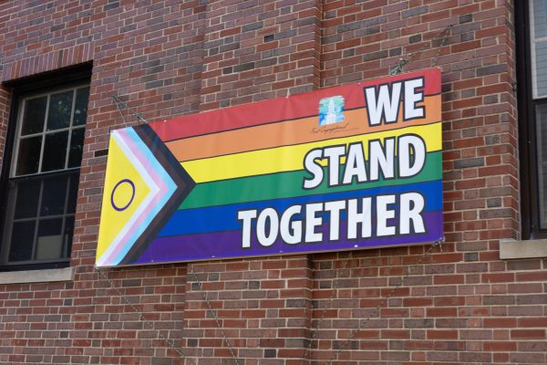 Pride flag banner with the words "we stand together." September 22, 2025.