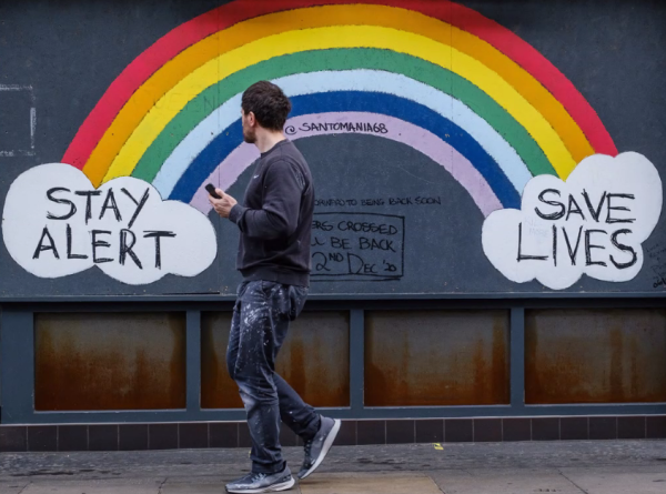 An individual walks in front of a wall mural, photo courtesy of PHMDC presentation