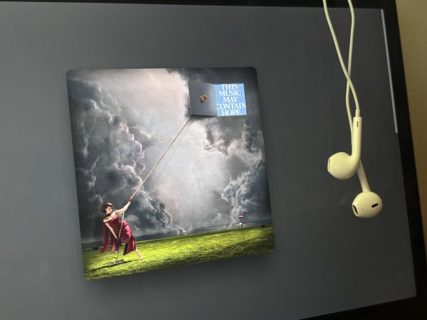 Raye's "THIS MUSIC MAY CONTAIN HOPE." and earbuds. April 4, 2026.
